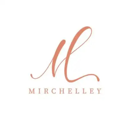 Elegant cursive monogram logo in coral pink featuring the letter ’M’ above the text ’MIRCHELLEY’