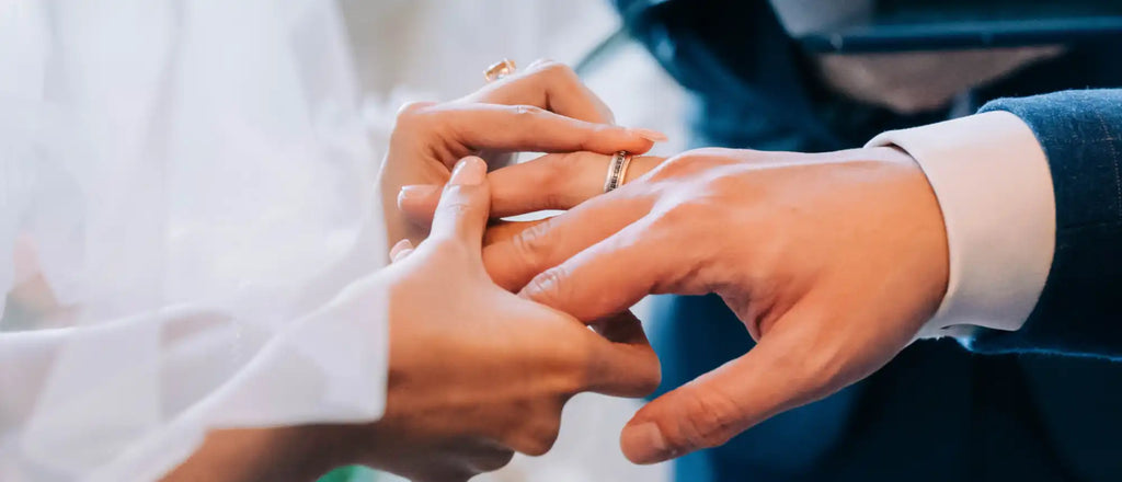 A wedding ring being placed on a finger during a ceremony.